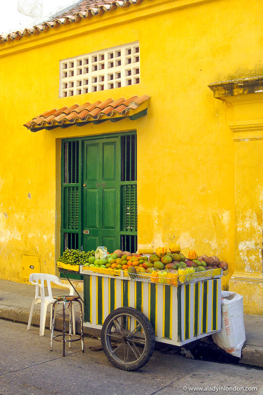 Yellow building and a fruit vendor in Cartagena old town