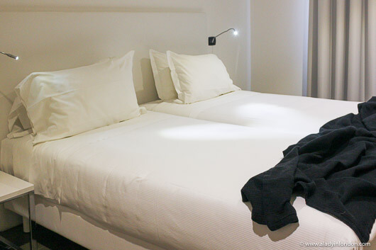 Bed in a hotel room in Bologna, Italy