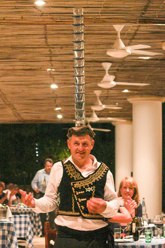 Man Balancing Glasses on His Head at a Restaurant in Cyprus